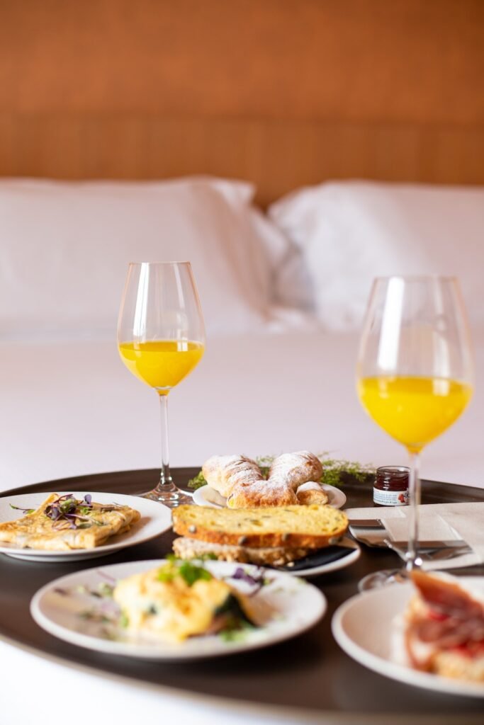 Breakfast in bed with orange juice and pastries.